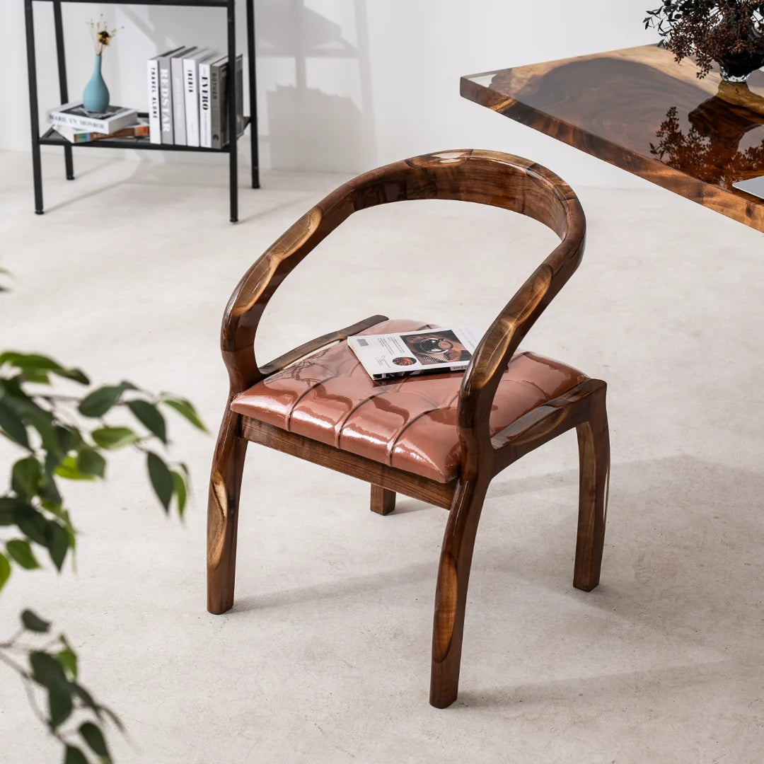 CH05 wood armchair with curved arms and a cognac tufted leather cushion